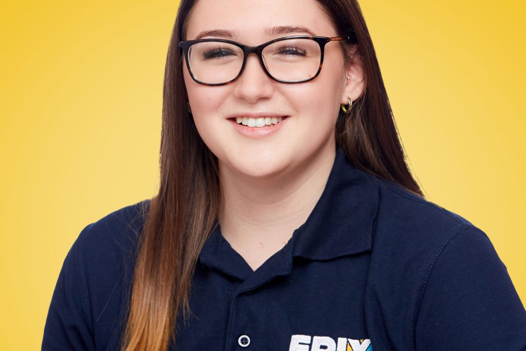 Ella in a dark blue EPIX shirt against a yellow background