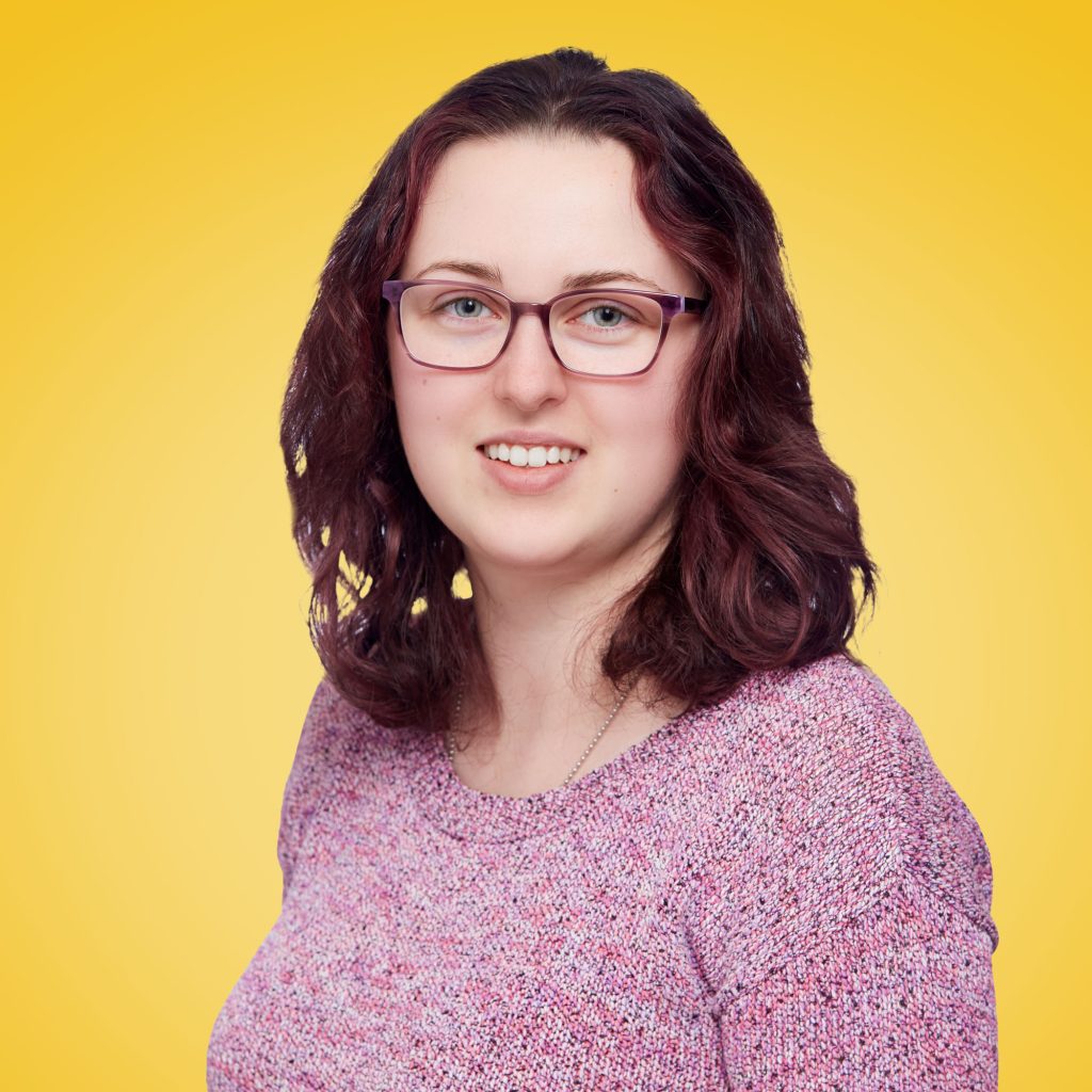 Jess smiling against a yellow background