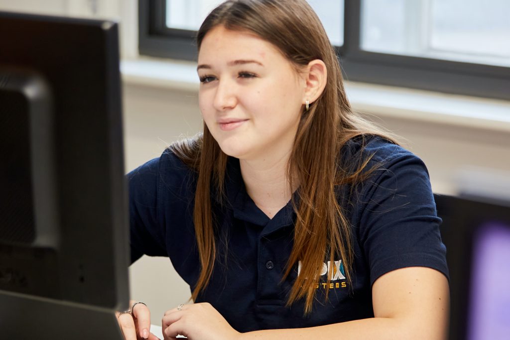 A photo of Ella at a computer in the EPIX offices